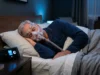 Older adult wearing CPAP full-face mask in bed at night for sleep apnea therapy
