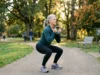 Elderly woman doing a squat exercise in a park to strengthen bones